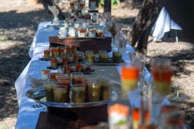 Borne photo interactive éclairée entourée de poteaux dorés et cordons rouges sur un tapis rouge dans une salle lumineuse.