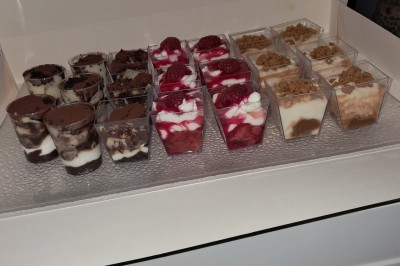 Borne photo interactive éclairée entourée de poteaux dorés et cordons rouges sur un tapis rouge dans une salle lumineuse.