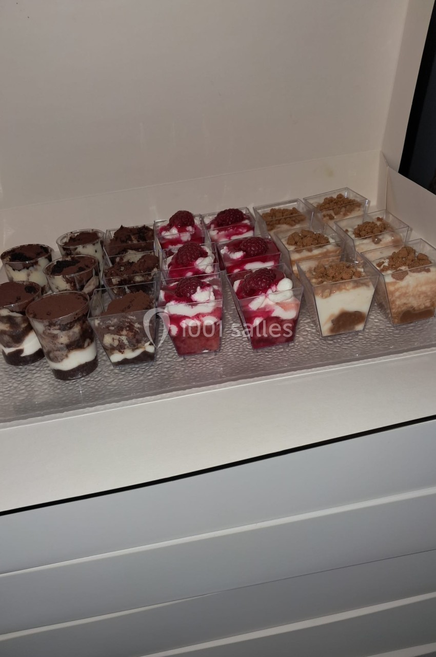 Assortiment de verrines sucrées avec des couches de chocolat, fruits rouges et crumble, présentées dans une boîte ouverte.