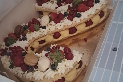 Borne photo interactive éclairée entourée de poteaux dorés et cordons rouges sur un tapis rouge dans une salle lumineuse.