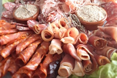 Borne photo interactive éclairée entourée de poteaux dorés et cordons rouges sur un tapis rouge dans une salle lumineuse.