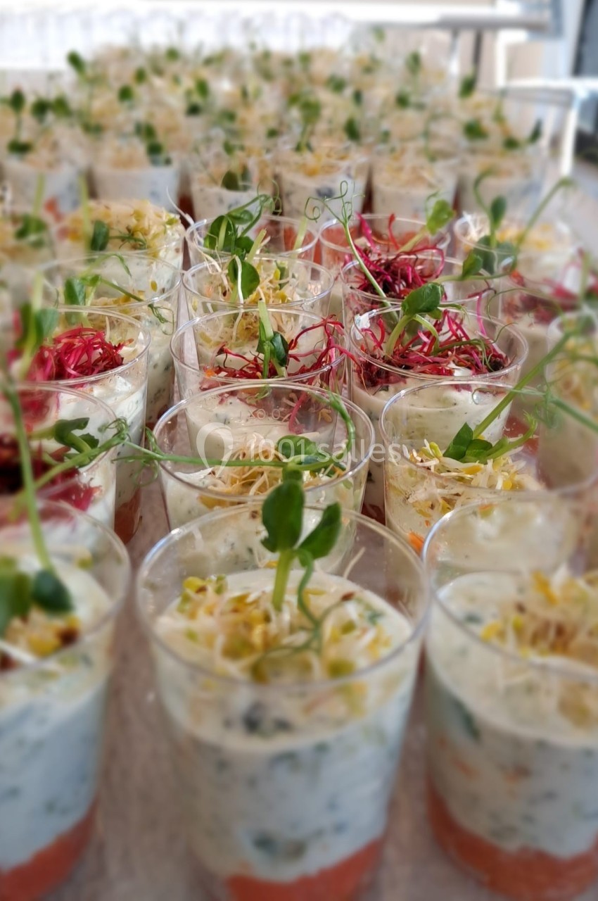 Verrines colorées composées de couches de légumes, crème et germes, disposées sur une table.