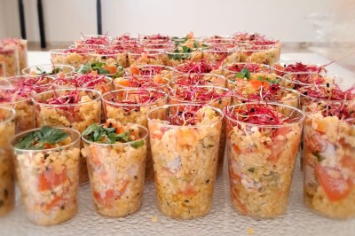 Borne photo interactive éclairée entourée de poteaux dorés et cordons rouges sur un tapis rouge dans une salle lumineuse.