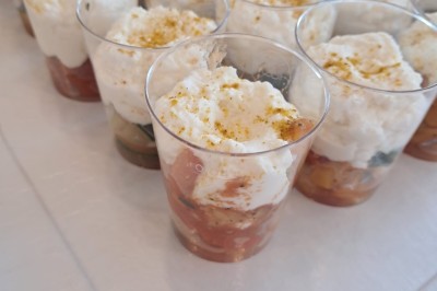 Borne photo interactive éclairée entourée de poteaux dorés et cordons rouges sur un tapis rouge dans une salle lumineuse.
