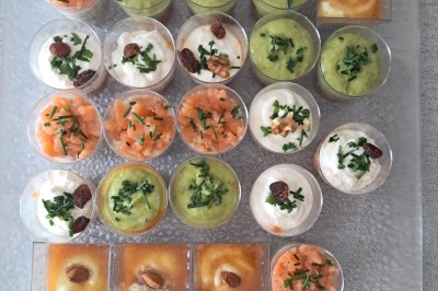 Borne photo interactive éclairée entourée de poteaux dorés et cordons rouges sur un tapis rouge dans une salle lumineuse.