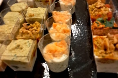 Borne photo interactive éclairée entourée de poteaux dorés et cordons rouges sur un tapis rouge dans une salle lumineuse.