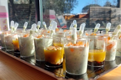 Borne photo interactive éclairée entourée de poteaux dorés et cordons rouges sur un tapis rouge dans une salle lumineuse.