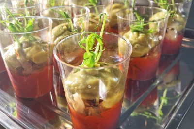 Borne photo interactive éclairée entourée de poteaux dorés et cordons rouges sur un tapis rouge dans une salle lumineuse.