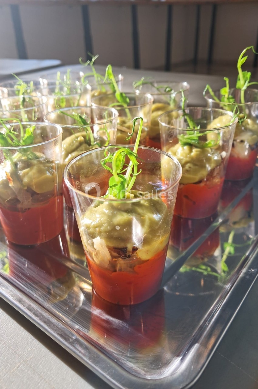 Verrines individuelles avec une base de sauce tomate, une couche de guacamole et une décoration de pousses vertes.