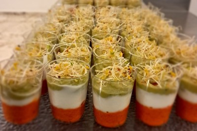 Borne photo interactive éclairée entourée de poteaux dorés et cordons rouges sur un tapis rouge dans une salle lumineuse.