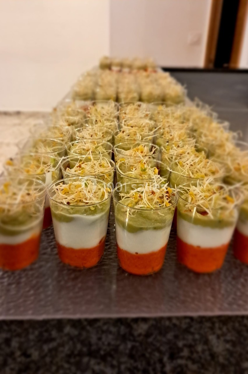 Verrines colorées en trois couches : purée de légumes rouges, crème blanche et mousse verte, garnies de pousses germées.