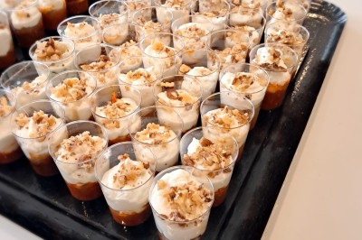 Borne photo interactive éclairée entourée de poteaux dorés et cordons rouges sur un tapis rouge dans une salle lumineuse.