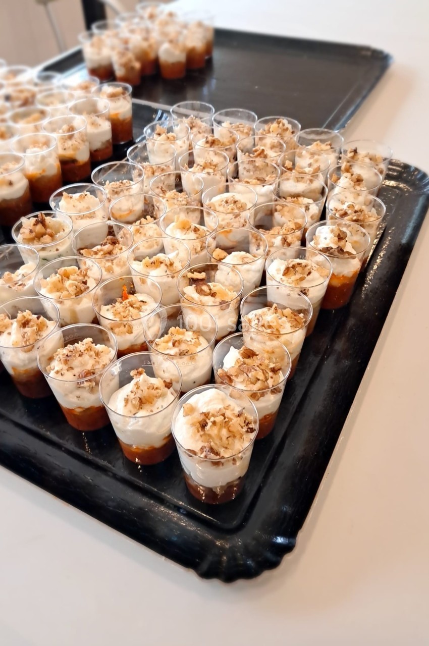 Plateaux de verrines individuelles garnies de couches de crème, caramel et éclats de noix.