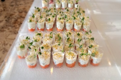 Borne photo interactive éclairée entourée de poteaux dorés et cordons rouges sur un tapis rouge dans une salle lumineuse.
