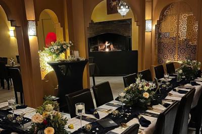 Miniature Location salle Liège (Liège) - Le Numidie #6 Un groupe d'hommes en tenues traditionnelles pose devant une décoration orientale et une affiche promotionnelle.