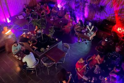 Miniature Location salle Liège (Liège) - Le Numidie #8 Un groupe d'hommes en tenues traditionnelles pose devant une décoration orientale et une affiche promotionnelle.