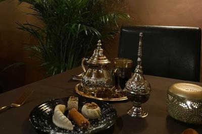 Miniature Location salle Liège (Liège) - Le Numidie #10 Un groupe d'hommes en tenues traditionnelles pose devant une décoration orientale et une affiche promotionnelle.