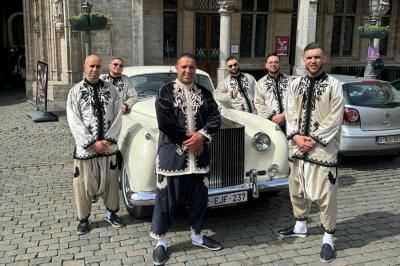 Miniature Location salle Liège (Liège) - Le Numidie #20 Un groupe d'hommes en tenues traditionnelles pose devant une décoration orientale et une affiche promotionnelle.