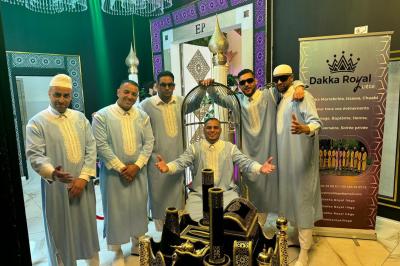 Miniature Location salle Liège (Liège) - Le Numidie #23 Un groupe d'hommes en tenues traditionnelles pose devant une décoration orientale et une affiche promotionnelle.