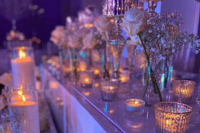 Miniature Traiteur Paris (Paris) - Eventicity #21 Bougies allumées et fleurs blanches disposées sur une table décorée pour un événement dans une ambiance tamisée.