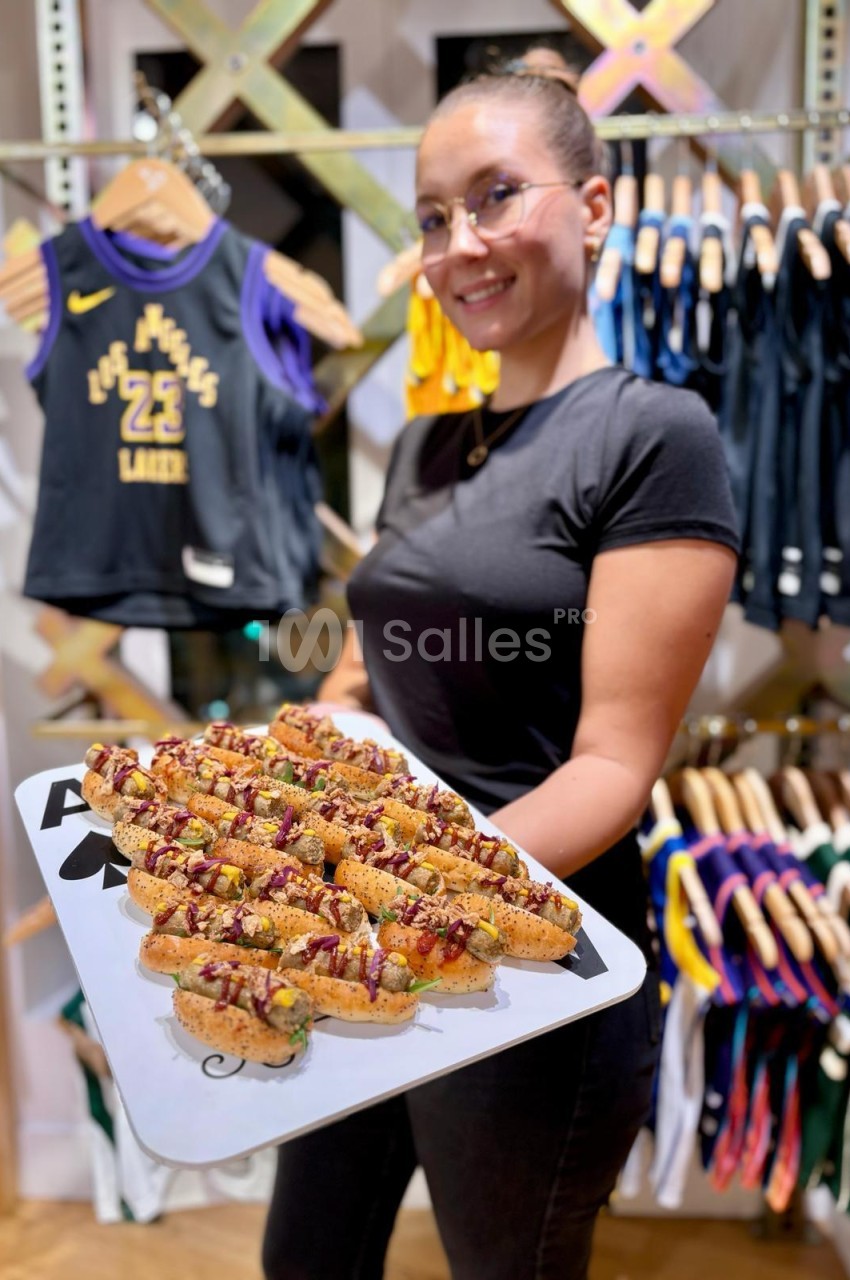 Brochettes garnies de sauce et d'herbes présentées sur un plateau blanc en intérieur.