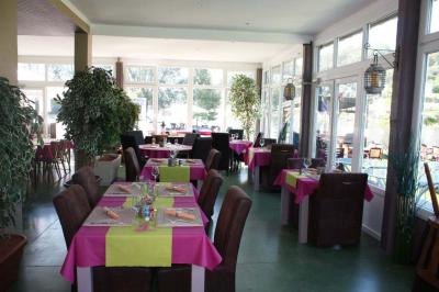 Aire de jeux en bois sur un sol sablé, entourée de verdure et située près d'une rivière et de collines.