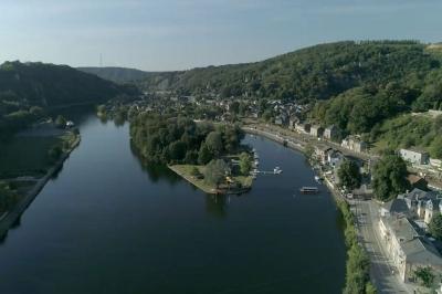 Miniature Location salle Yvoir (Namur) - L’île d’Yvoir  #7 Aire de jeux en bois sur un sol sablé, entourée de verdure et située près d'une rivière et de collines.