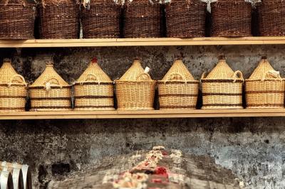 Intérieur d'un bar cosy avec un comptoir en bois, des tabourets hauts et des tables alignées dans un espace chaleureux.