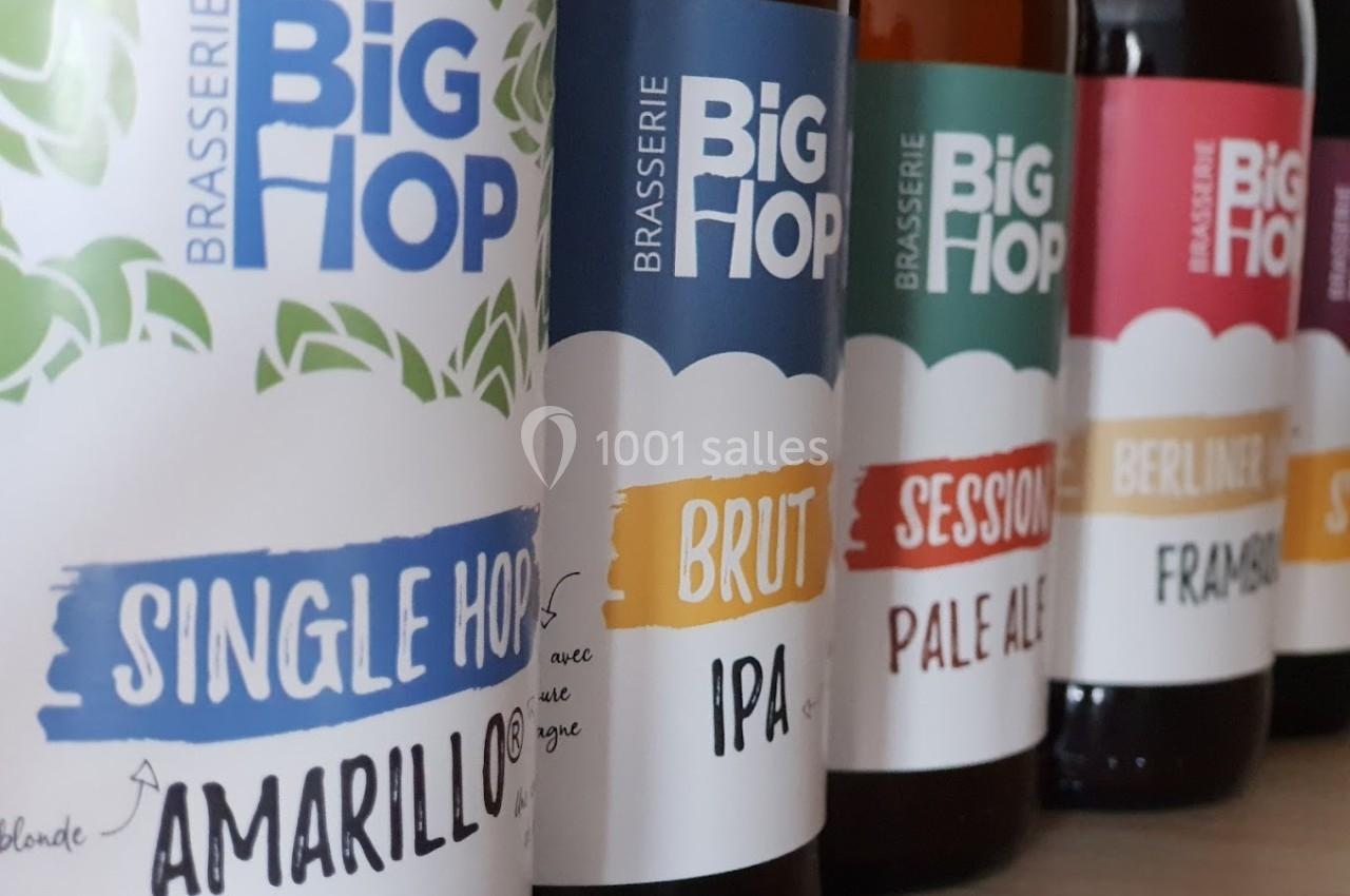 Bouteilles de bière artisanale alignées, étiquettes colorées indiquant différents styles et saveurs.