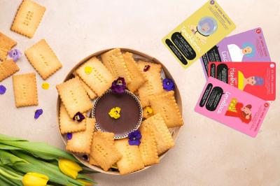 Plateau coloré de crudités, fromages, dips, fruits secs et fleurs comestibles disposés de manière artistique.