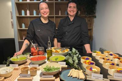 Plateau coloré de crudités, fromages, dips, fruits secs et fleurs comestibles disposés de manière artistique.