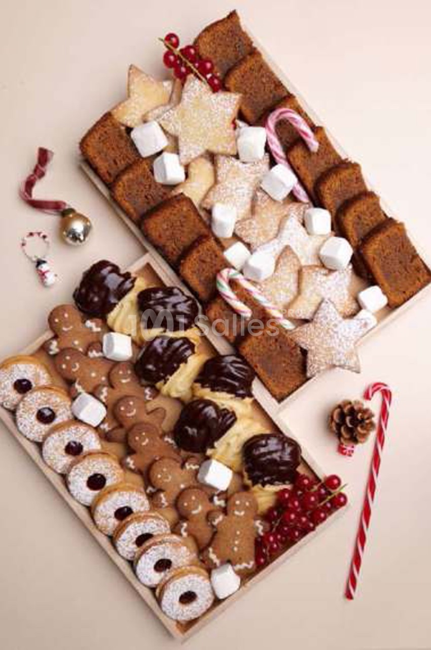 Deux plateaux en bois de biscuits de Noël : pain d'épices, sablés étoilés, biscuits sandwichs à la confiture, chocolat, guimauves et cannes en sucre. Let me check length: roughly 150 characters. Too long. Need ≤125. Revised: "Plateaux en bois de biscuits
