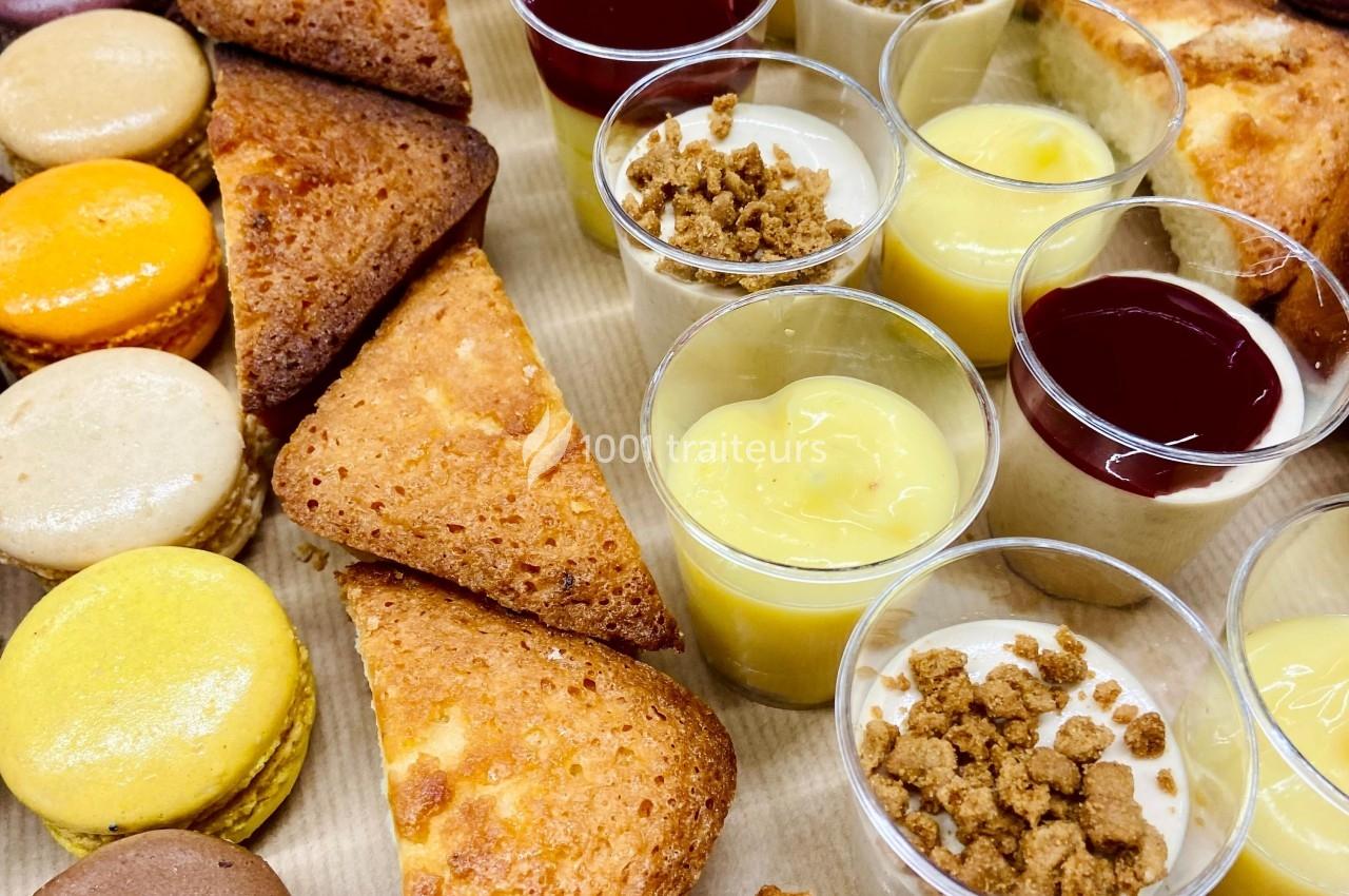 Assortiment de desserts comprenant macarons, financiers et verrines variées sur un plateau.