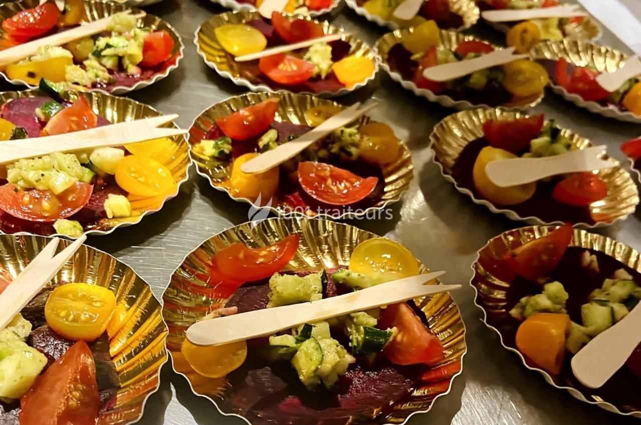 Assiettes dorées contenant des portions de légumes colorés, avec des tomates cerises, concombres et betteraves, accompagnées…