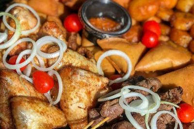 Miniature Traiteur Lyon 9 (Rhône) - Traiteur une Faim d'Apprendre #30 Assortiment de grillades, samoussas, légumes et sauce, garni d'oignons et tomates cerises.