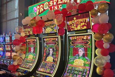 Miniature Location salle Hyères (Var) - Pasino de Hyères #15 Deux machines à sous lumineuses avec écrans colorés, une personne assise devant l'une d'elles dans un casino.