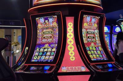 Miniature Location salle Hyères (Var) - Pasino de Hyères #16 Deux machines à sous lumineuses avec écrans colorés, une personne assise devant l'une d'elles dans un casino.