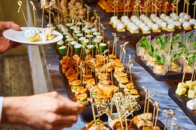 Personnes pratiquant le yoga sur une plage au coucher du soleil, en position debout avec les bras levés.