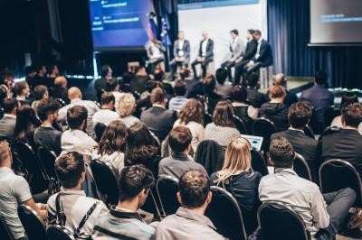 Personnes pratiquant le yoga sur une plage au coucher du soleil, en position debout avec les bras levés.