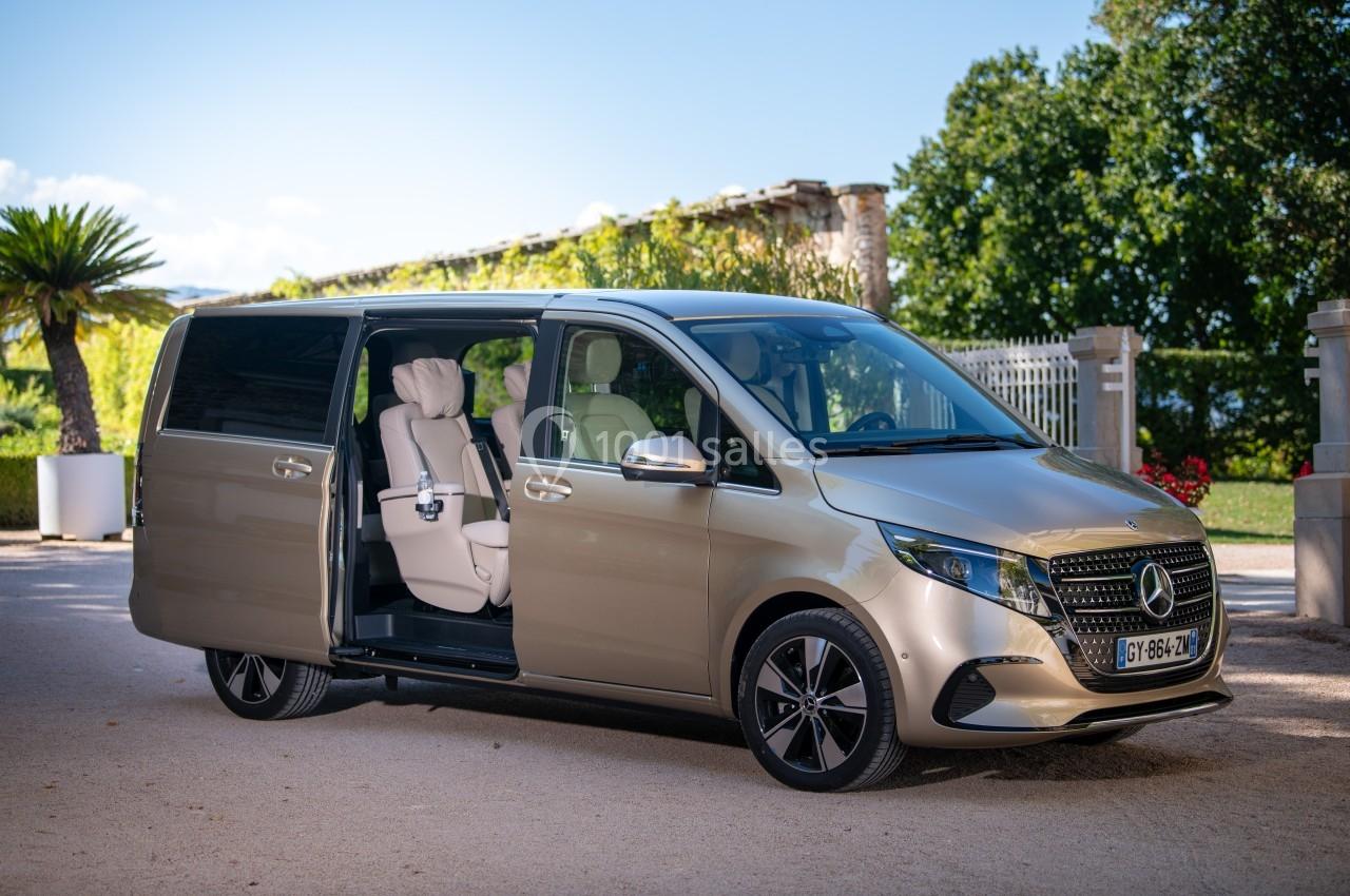 Monospace beige avec porte latérale coulissante ouverte, révélant des sièges intérieurs clairs, stationné en extérieur.