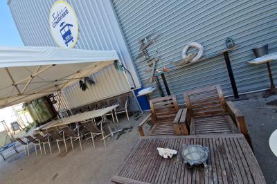 Miniature Location salle Sète (Hérault) - Le Truck de la Conserverie #2 Des personnes assises à des tables sous une pergola ombragée, discutant et partageant un moment convivial.