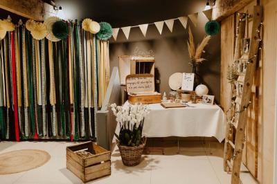 Salle décorée avec des fûts recyclés en tables, éclairage chaleureux et éléments rustiques en bois.