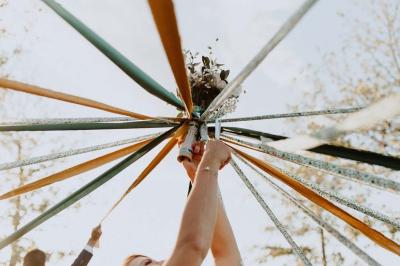 Salle décorée avec des fûts recyclés en tables, éclairage chaleureux et éléments rustiques en bois.