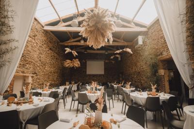 Salle décorée avec des fûts recyclés en tables, éclairage chaleureux et éléments rustiques en bois.