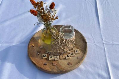 Salle décorée avec des fûts recyclés en tables, éclairage chaleureux et éléments rustiques en bois.