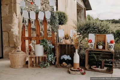 Salle décorée avec des fûts recyclés en tables, éclairage chaleureux et éléments rustiques en bois.