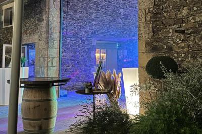 Salle décorée avec des fûts recyclés en tables, éclairage chaleureux et éléments rustiques en bois.