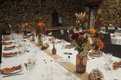 Salle décorée avec des fûts recyclés en tables, éclairage chaleureux et éléments rustiques en bois.