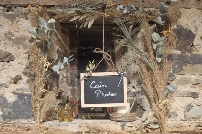 Salle décorée avec des fûts recyclés en tables, éclairage chaleureux et éléments rustiques en bois.