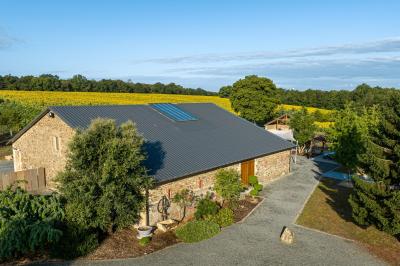 Salle décorée avec des fûts recyclés en tables, éclairage chaleureux et éléments rustiques en bois.